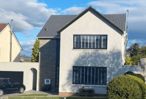 Modernised detached home with a fresh exterior, featuring updated roofing, clean landscaping, and a well-maintained façade, illustrating the impact of a full house refurbishment on property value.